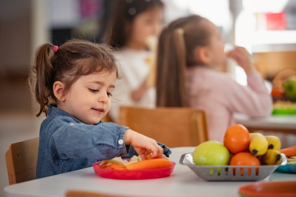 Young girl enjoys a healthy snack from Mini Meals kids meal delivery.