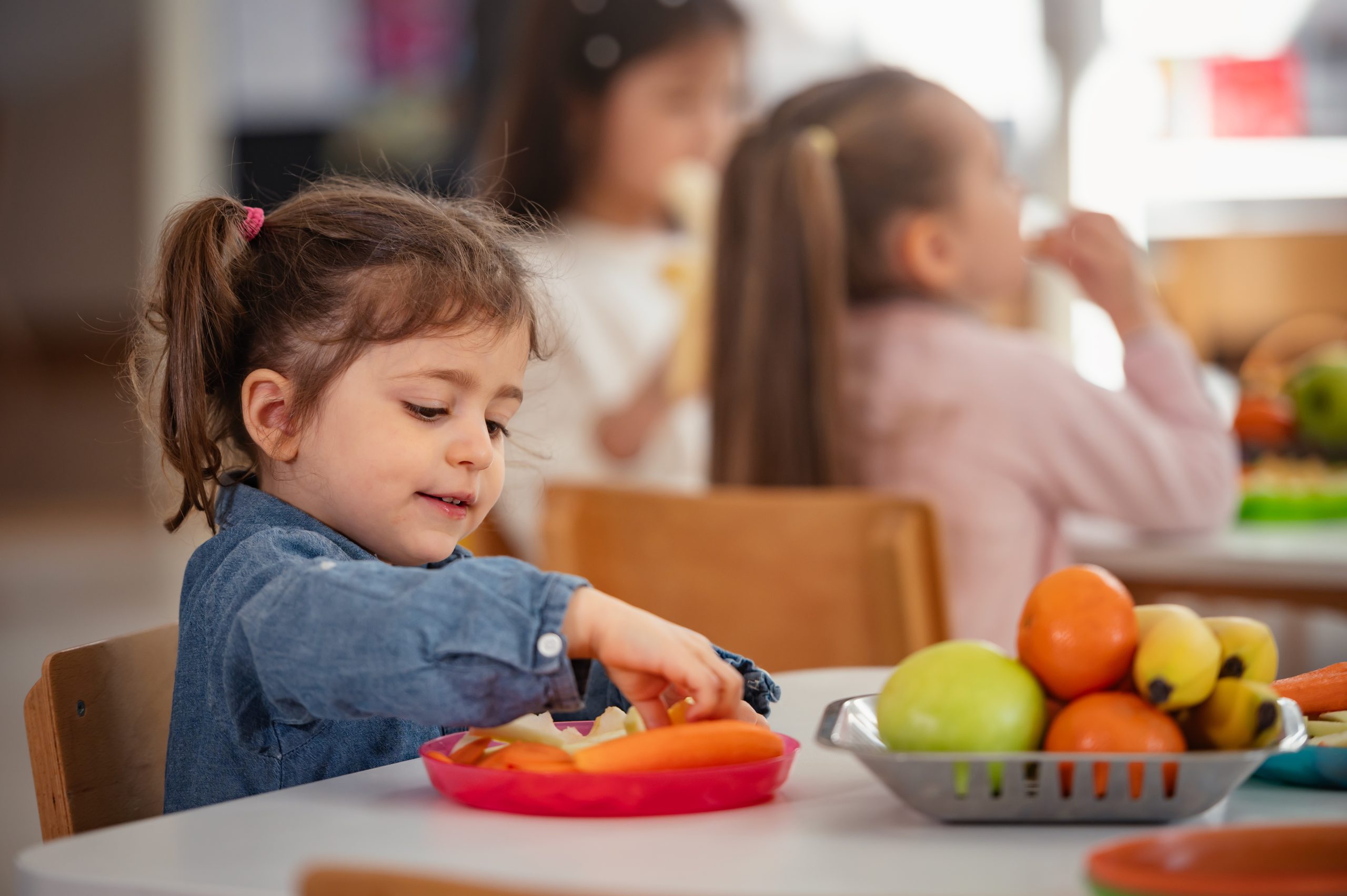 Young girl enjoys a healthy snack from Mini Meals kids meal delivery.